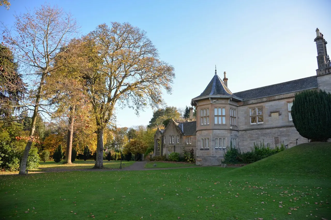 Lauriston Castle bay window beside a lawn and autumn trees