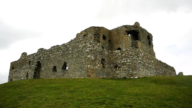 Auchindoun Castle: tower and outer wall on a grassy hillside