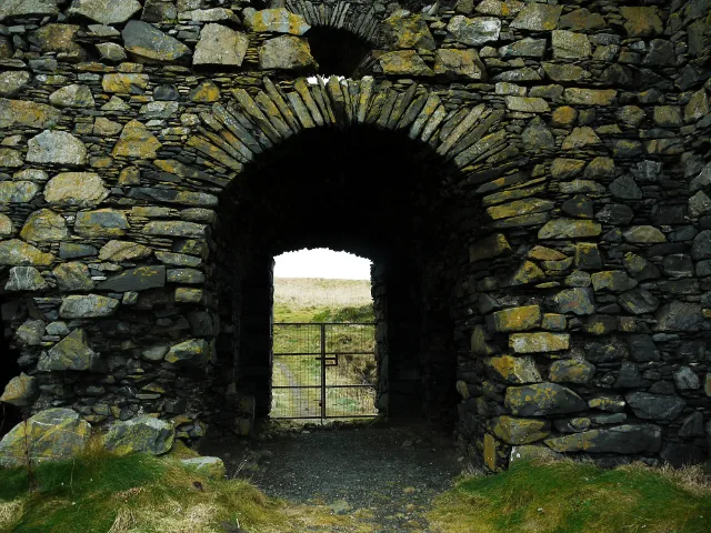 Barrera metálica bajo el arco de entrada de Dunskey Castle