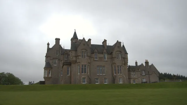 Weiter Blick auf Glengorm Castle über das grüne Gelände unter grauen Wolken