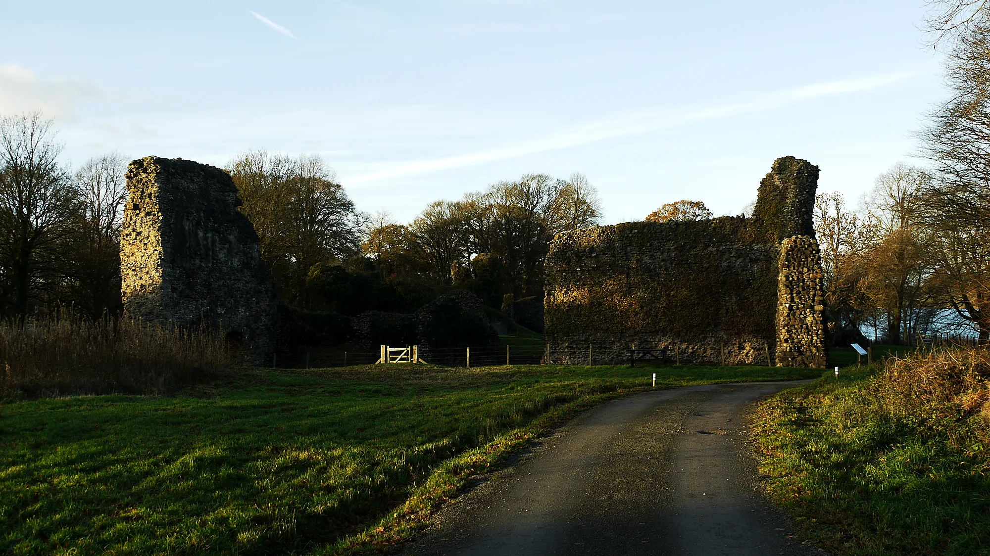 Sunlit outer walls and approach road — Lochmaben Castle