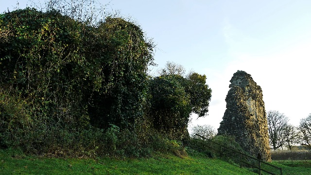 Ivy-covered ruin beside a tall wall fragment — Lochmaben Castle