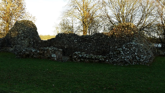 Low stone walls beneath autumn trees — Lochmaben Castle