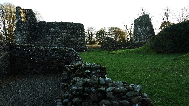 Low rubble walls framing a view across the ruins — Lochmaben Castle